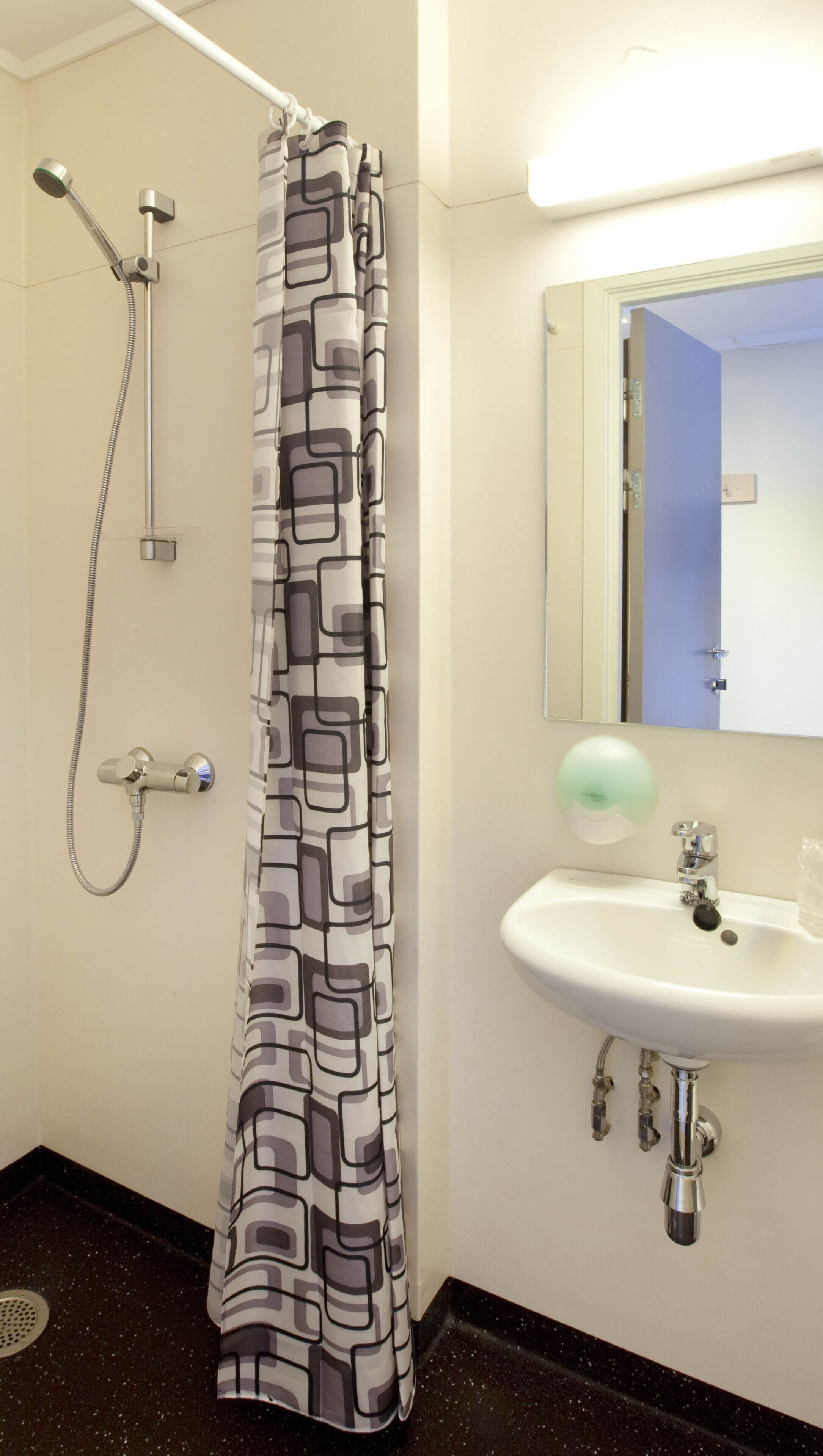 A bathroom with a shower, a sink, and a mirror.