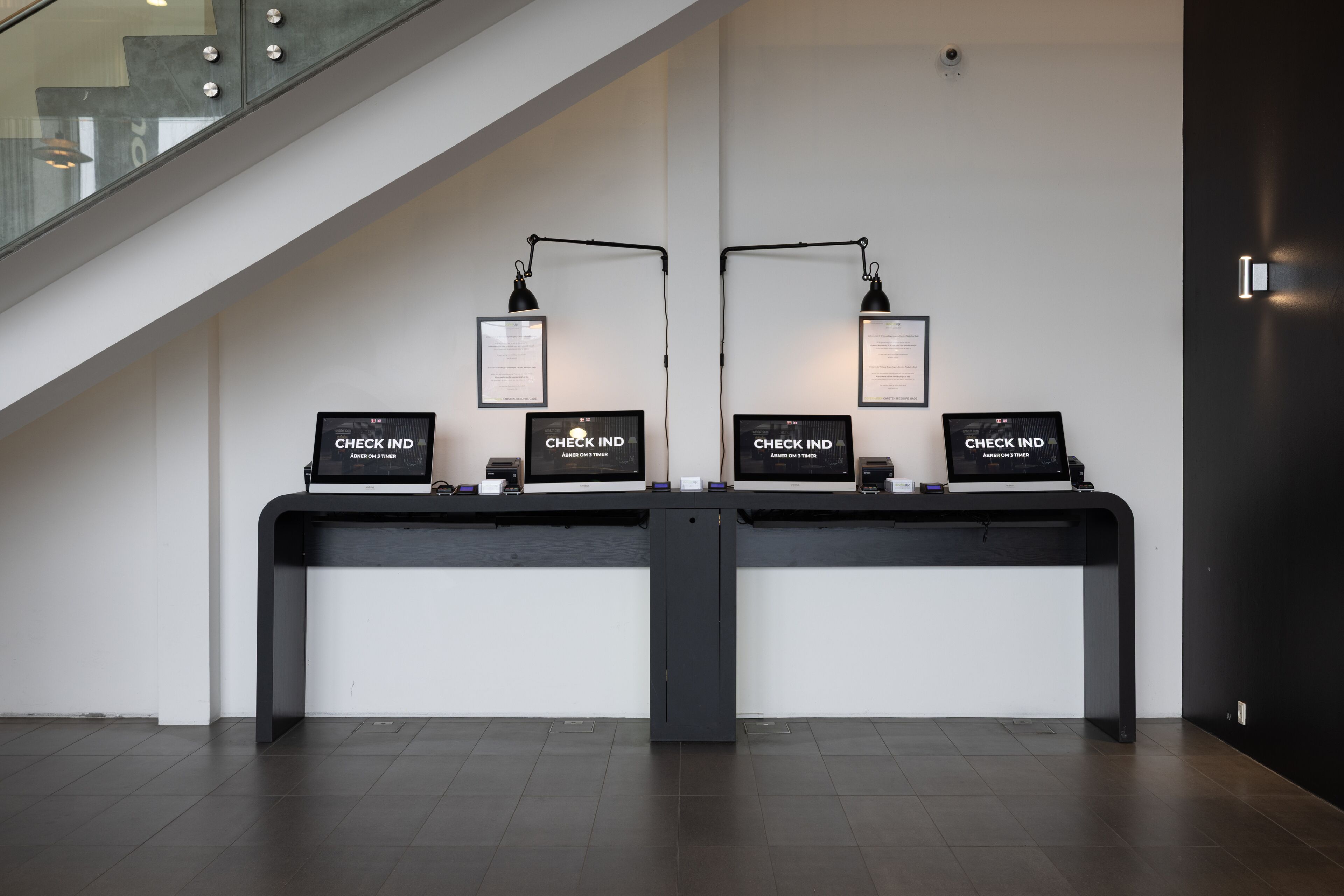 A reception desk with two check-in stations, each with a computer and a sign that reads "CHECK IN".