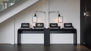 Un mostrador de recepción con dos puestos de registro, cada uno con una computadora y un cartel que dice 'CHECK IN'.