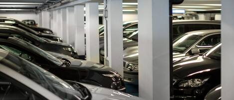 A parking garage with multiple rows of parked cars.