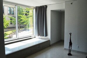 Une pièce dotée d’une grande fenêtre, d’un radiateur et d’une statue.