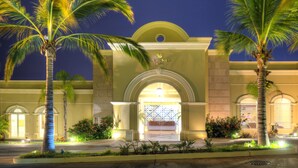 A hotel entrance with a grand archway, palm trees, and a well-lit facade. - Pueblo Bonito Emerald Luxury Villas & Spa - All Inclusive (Mazatlán)