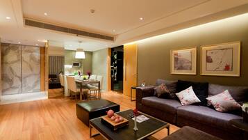 A modern living room with a sofa, coffee table, and dining area.