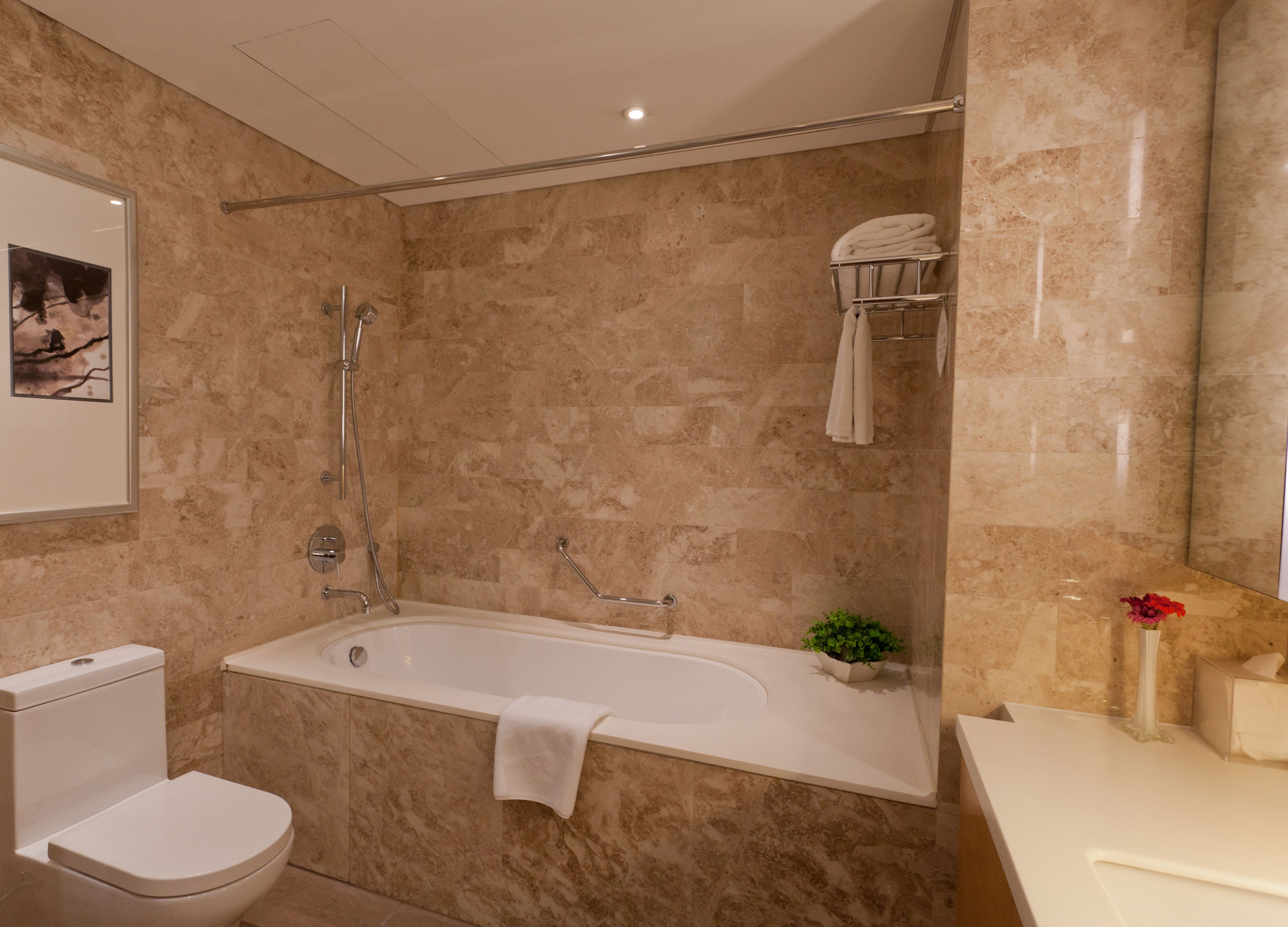 A modern bathroom with a bathtub, toilet, and shower.