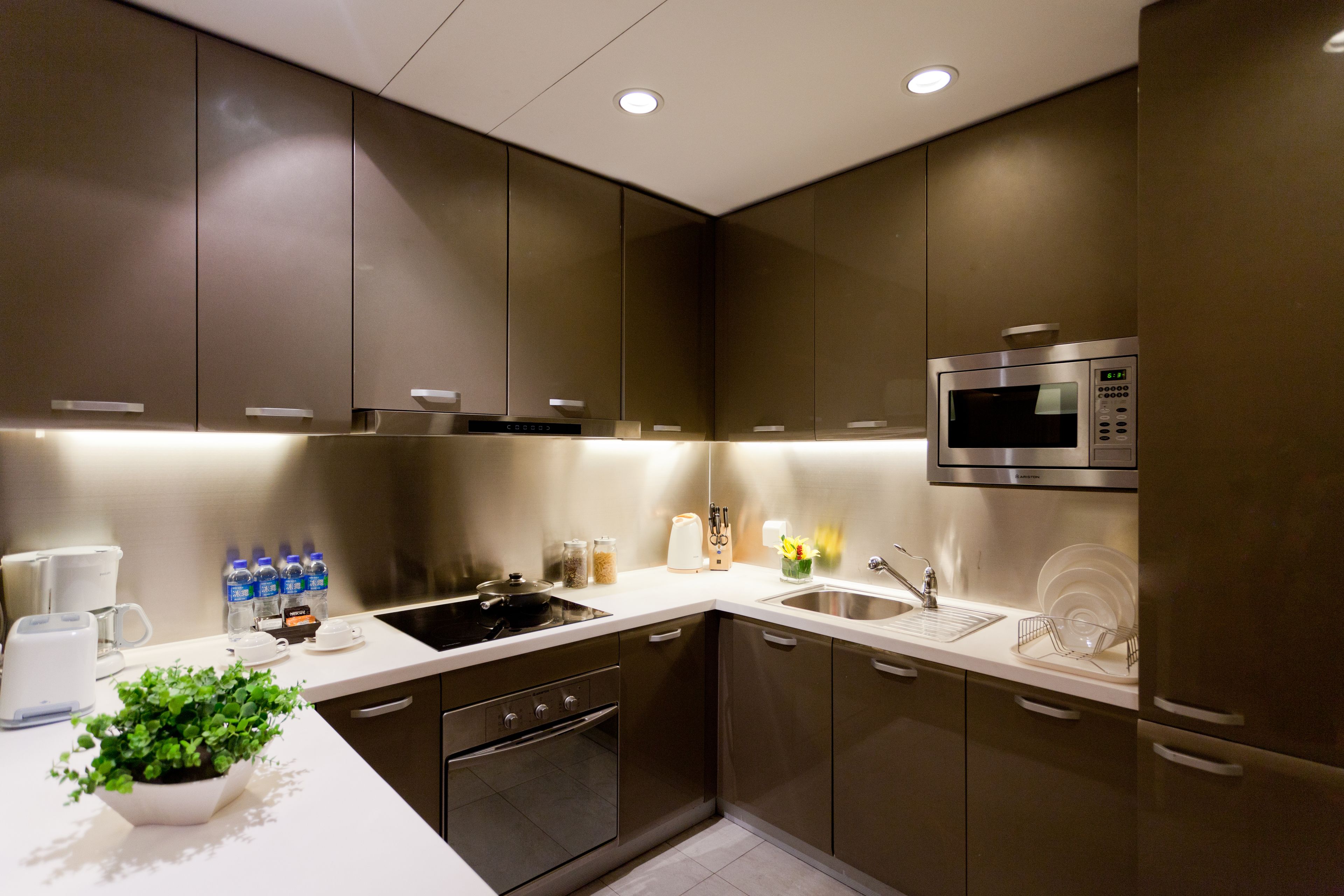 Una cocina moderna con electrodomésticos de acero inoxidable, un microondas y un lavamanos.