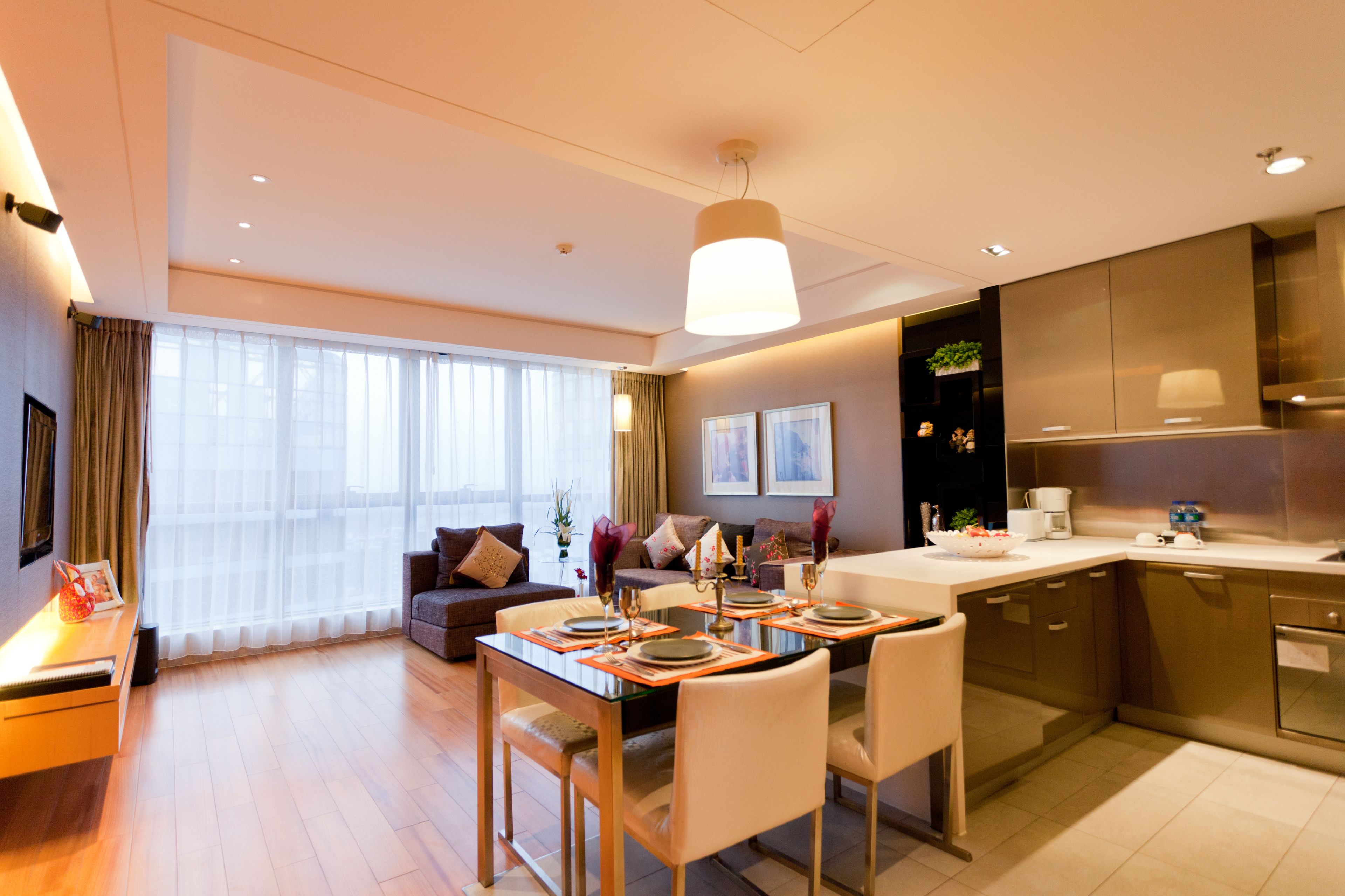 Een moderne hotelkamer met een eethoek, een bank en een keuken.