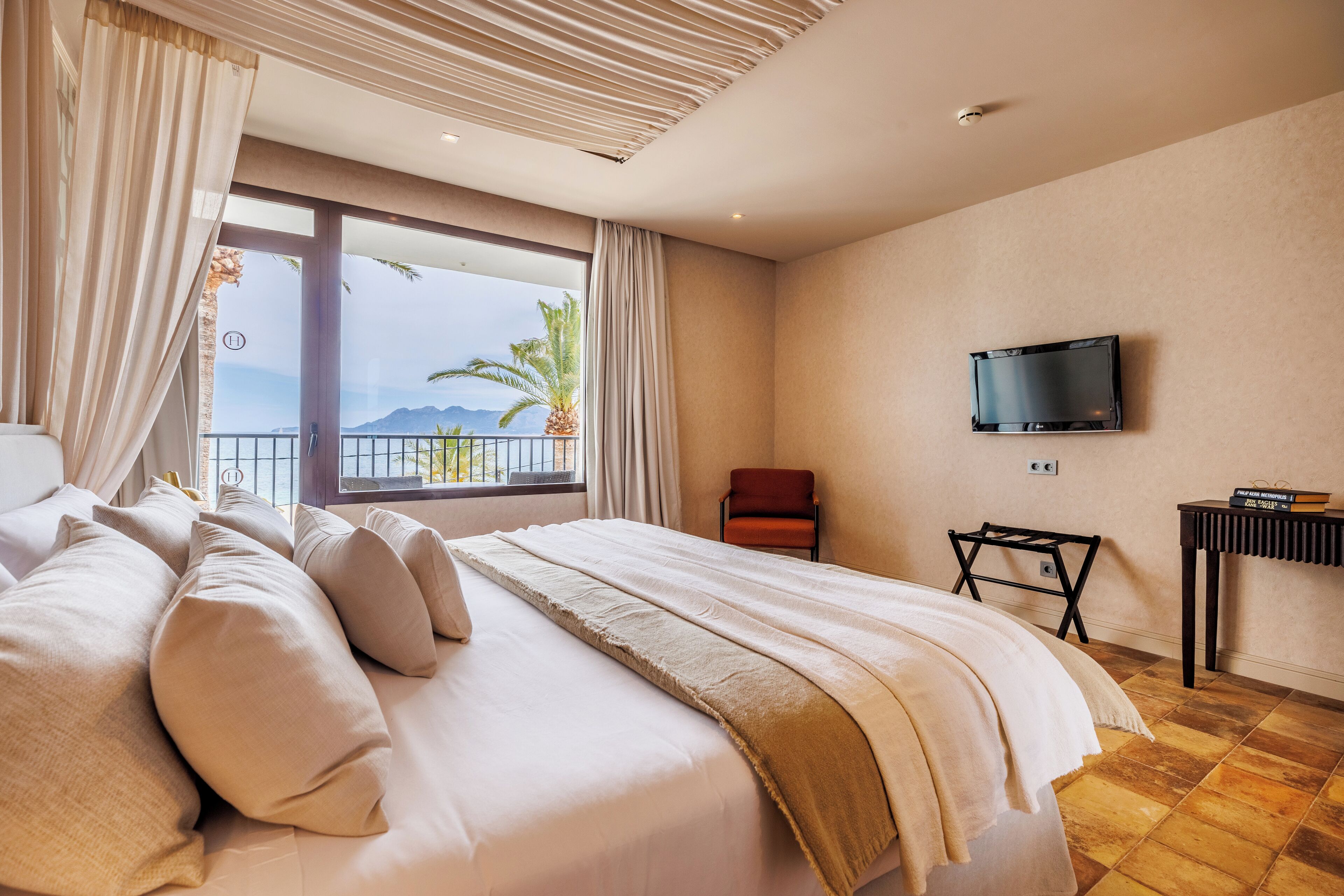Une chambre d’hôtel avec un grand lit, un téléviseur fixé au mur et une vue sur l’extérieur.