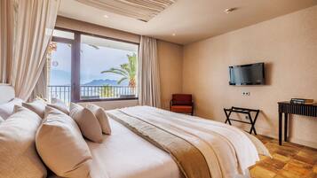 Habitación de hotel con una cama grande, un televisor montado en la pared y vistas al exterior.