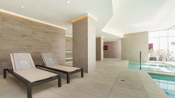 Relax in style with comfortable lounge chairs overlooking a serene pool area.