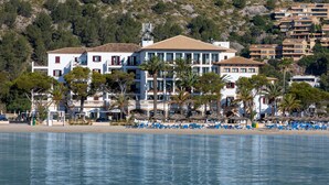 Un hotel costero con varios pisos, balcones y ubicación frente a la playa.