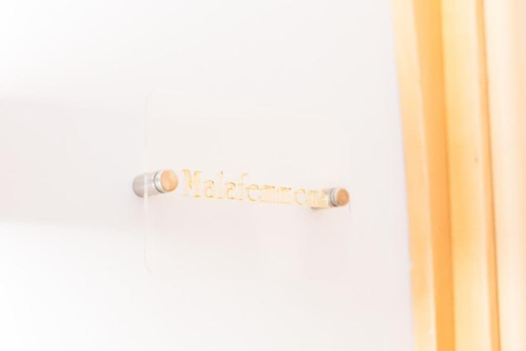A white door with a nameplate that reads 'Malafemme.'