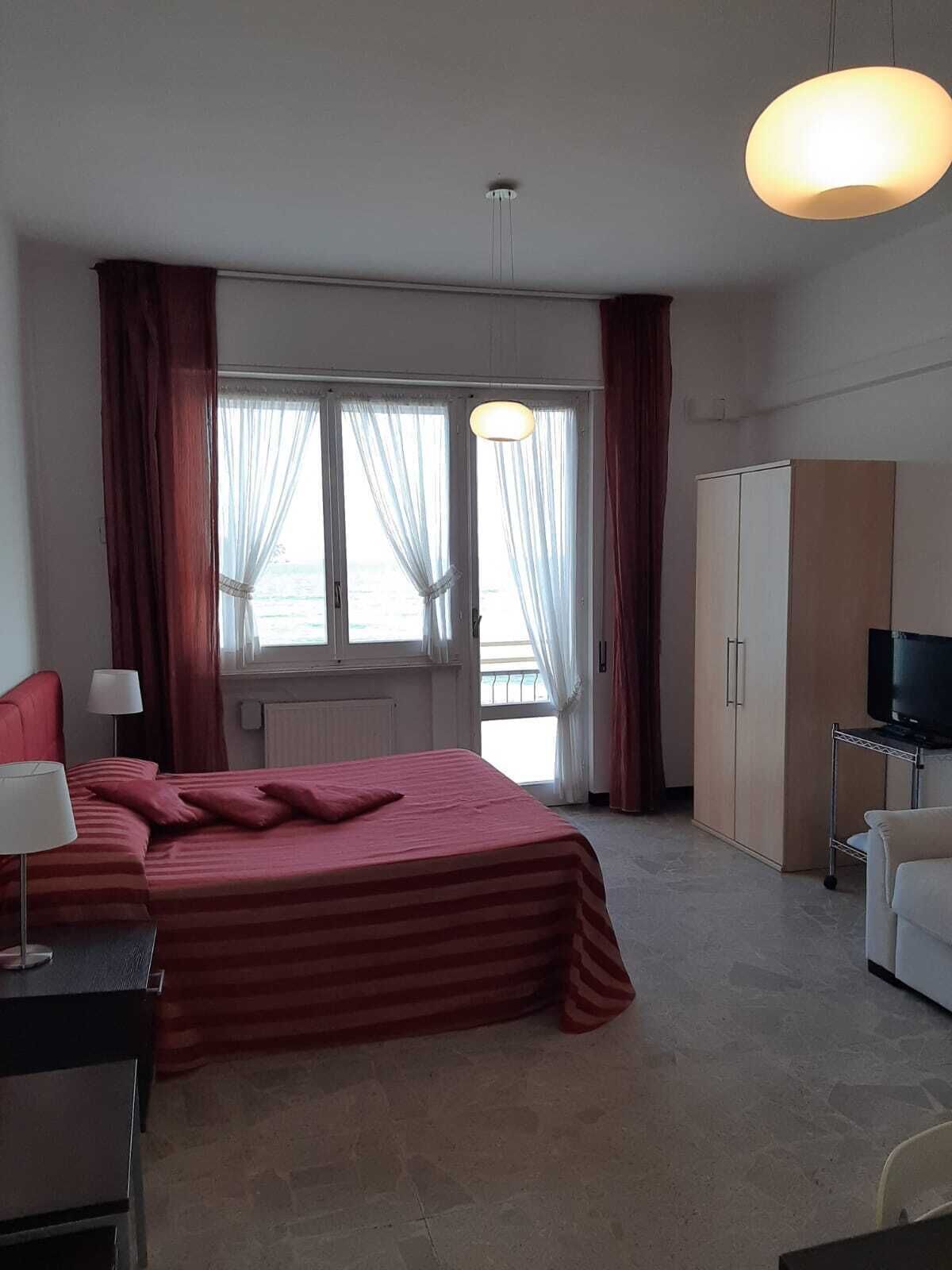 Une chambre d’hôtel équipée d’un lit, d’un bureau, d’une télévision et d’une armoire.