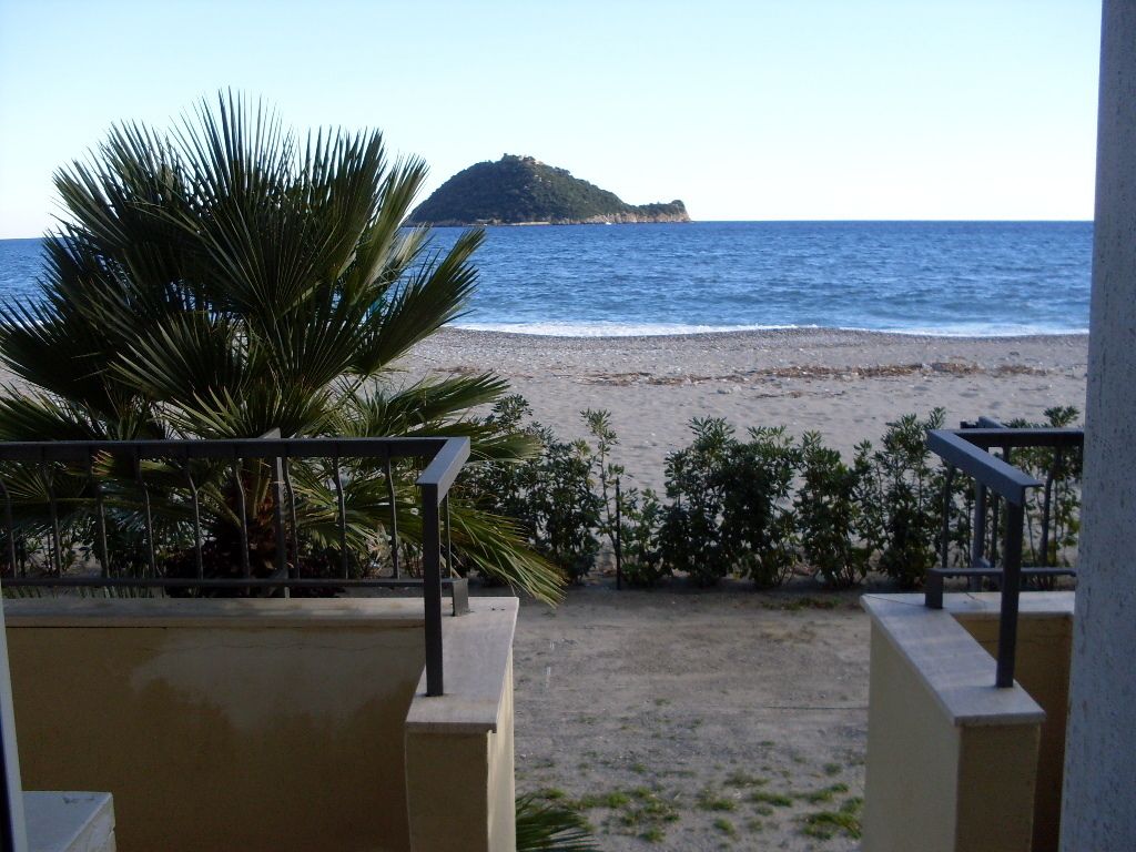 Un balcon donnant sur une plage et une petite île.