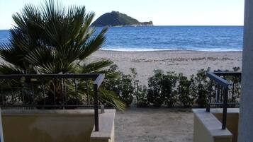 A balcony with a view of a beach and a small island.