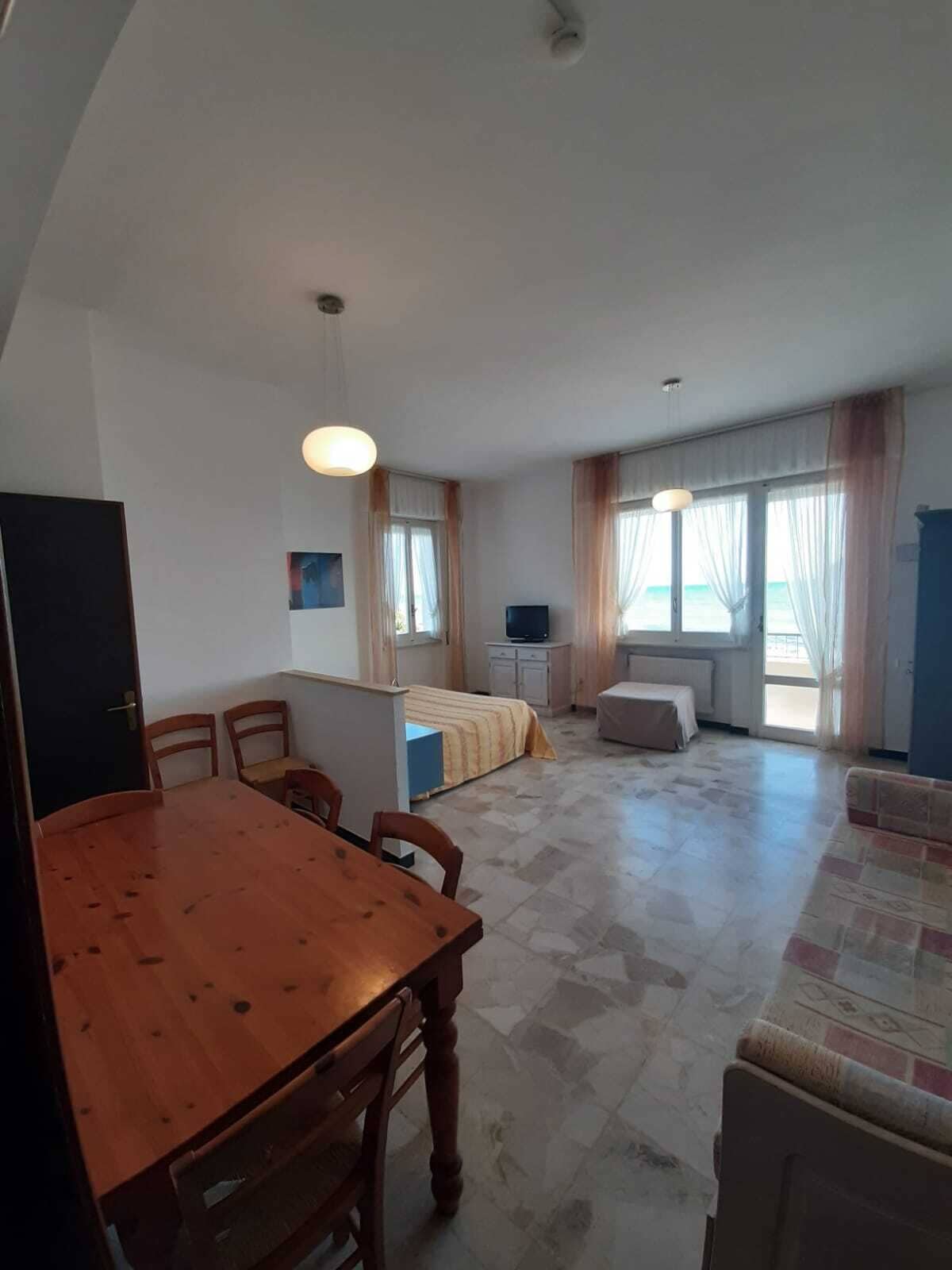 A compact living space with a dining area, kitchenette, and a bed.