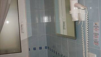 Un baño con lavabo, espejo y secador de pelo.