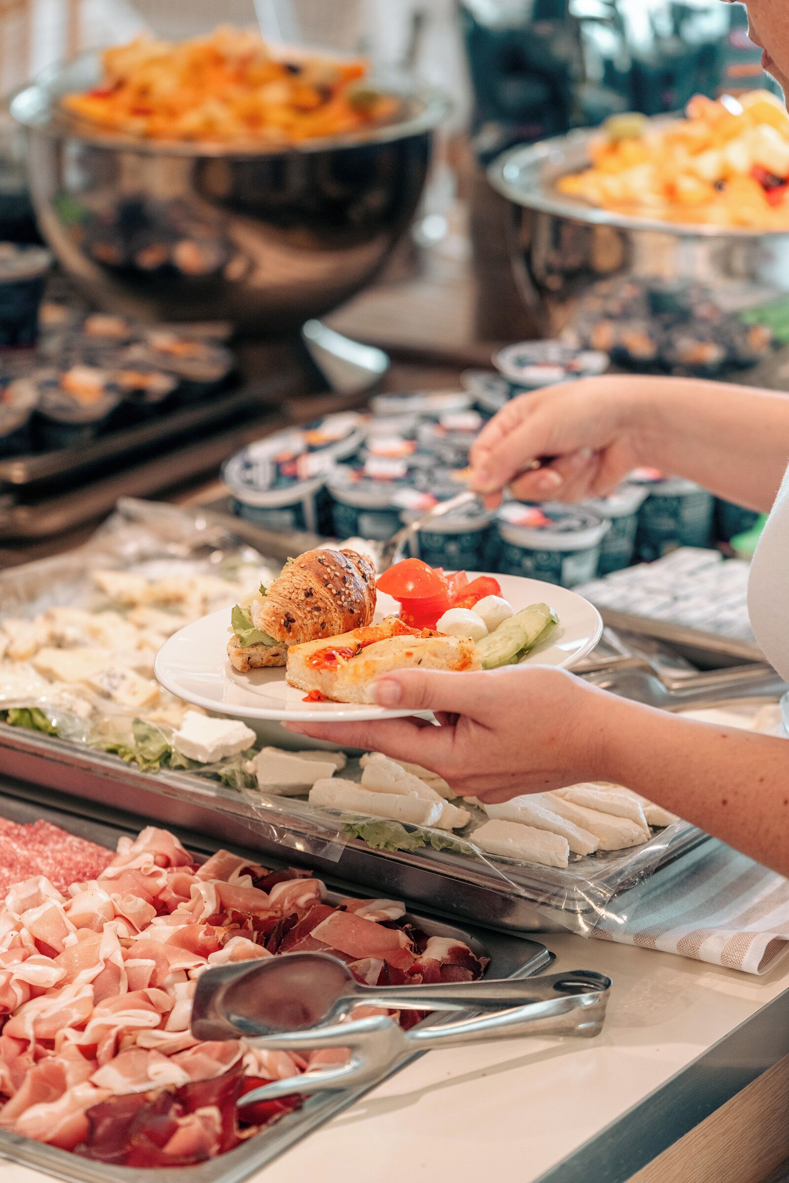 Ein Buffet mit verschiedenen Speisen, darunter Fleisch, Käse und Salate.