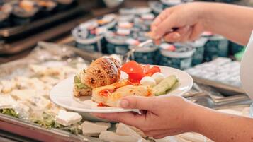 Ein Buffet mit verschiedenen Speisen, darunter Fleisch, Käse und Salate.