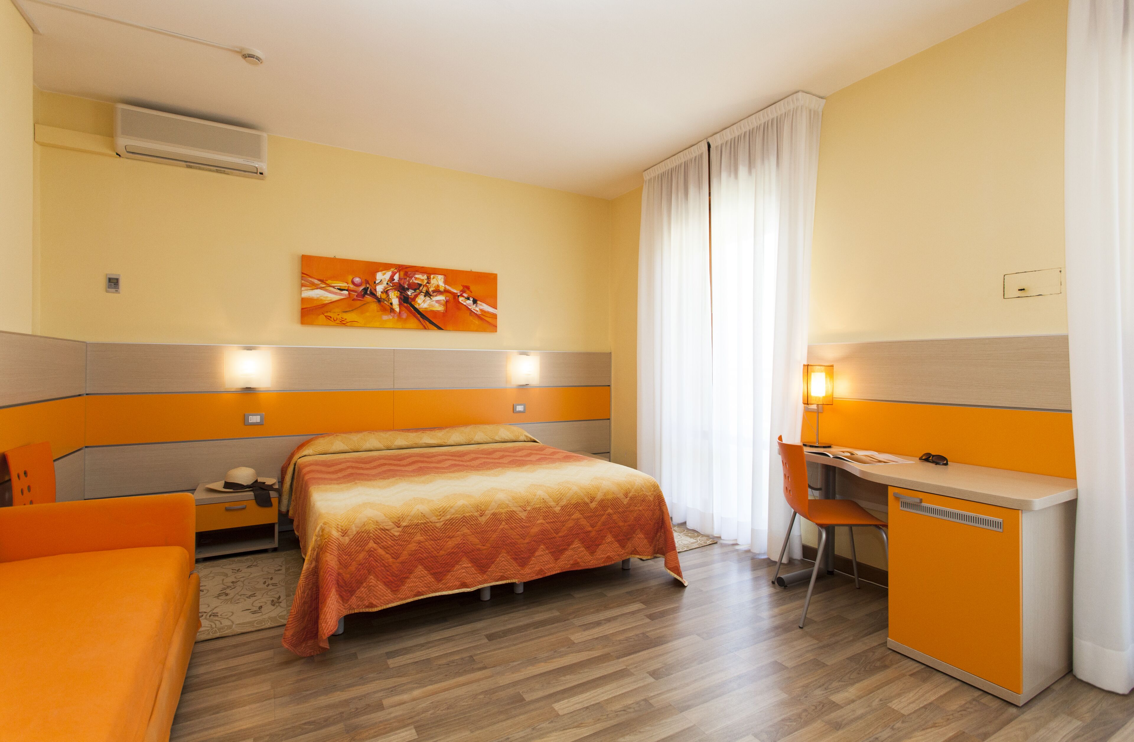 Une chambre d’hôtel avec un lit, un bureau et une chaise.