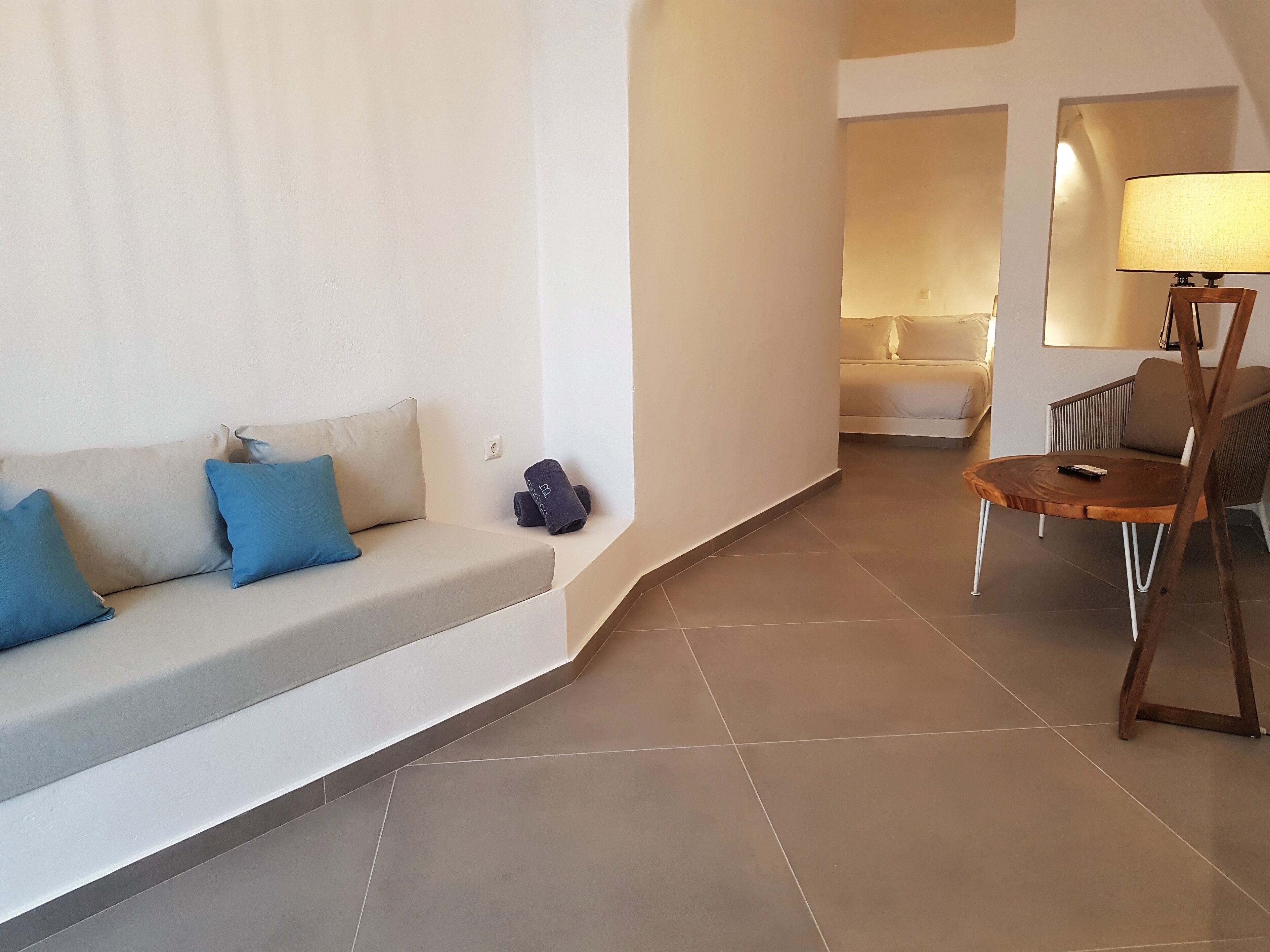 A modern living room with a sofa, a round wooden table, and a chair.