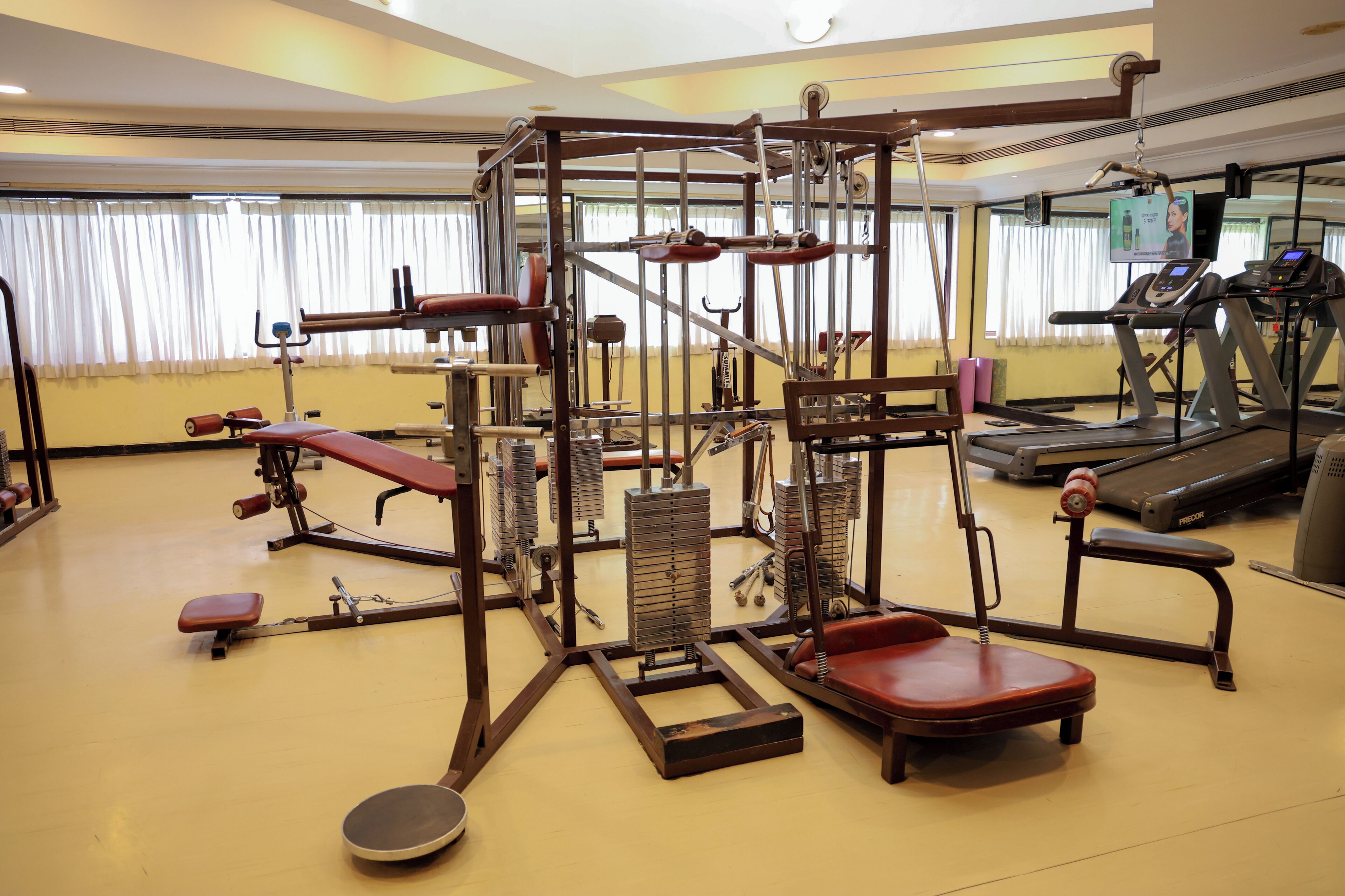 Une salle de sport équipée de divers appareils d’exercice, notamment des tapis de course et des appareils de musculation.