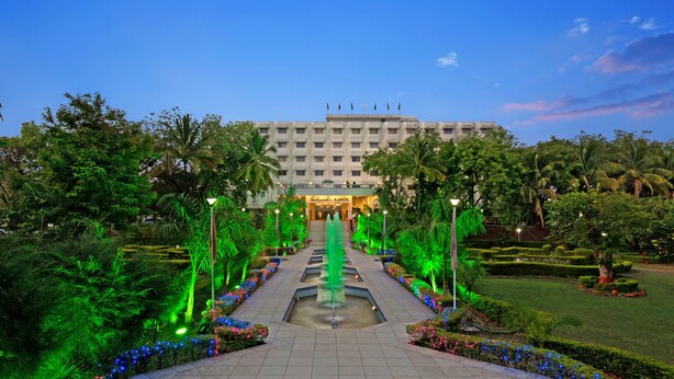 A hotel with a central fountain, surrounded by well-maintained gardens and a clear sky. - Ambassador Ajanta (Chhatrapati Sambhajinagar)