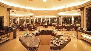 A spacious hotel lobby with a central seating area, multiple dining tables, and a reception desk. - Ambassador Ajanta (Chhatrapati Sambhajinagar)