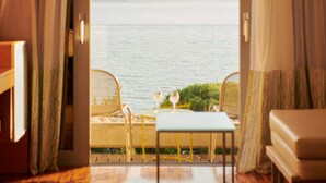 A hotel room with a bed, a table with a glass, and a view of the sea. - Bluesun Hotel Soline (Brela)