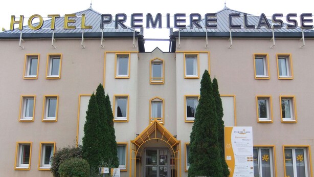 A hotel entrance with a sign reading "HOTEL PREMIERE CLASSE".