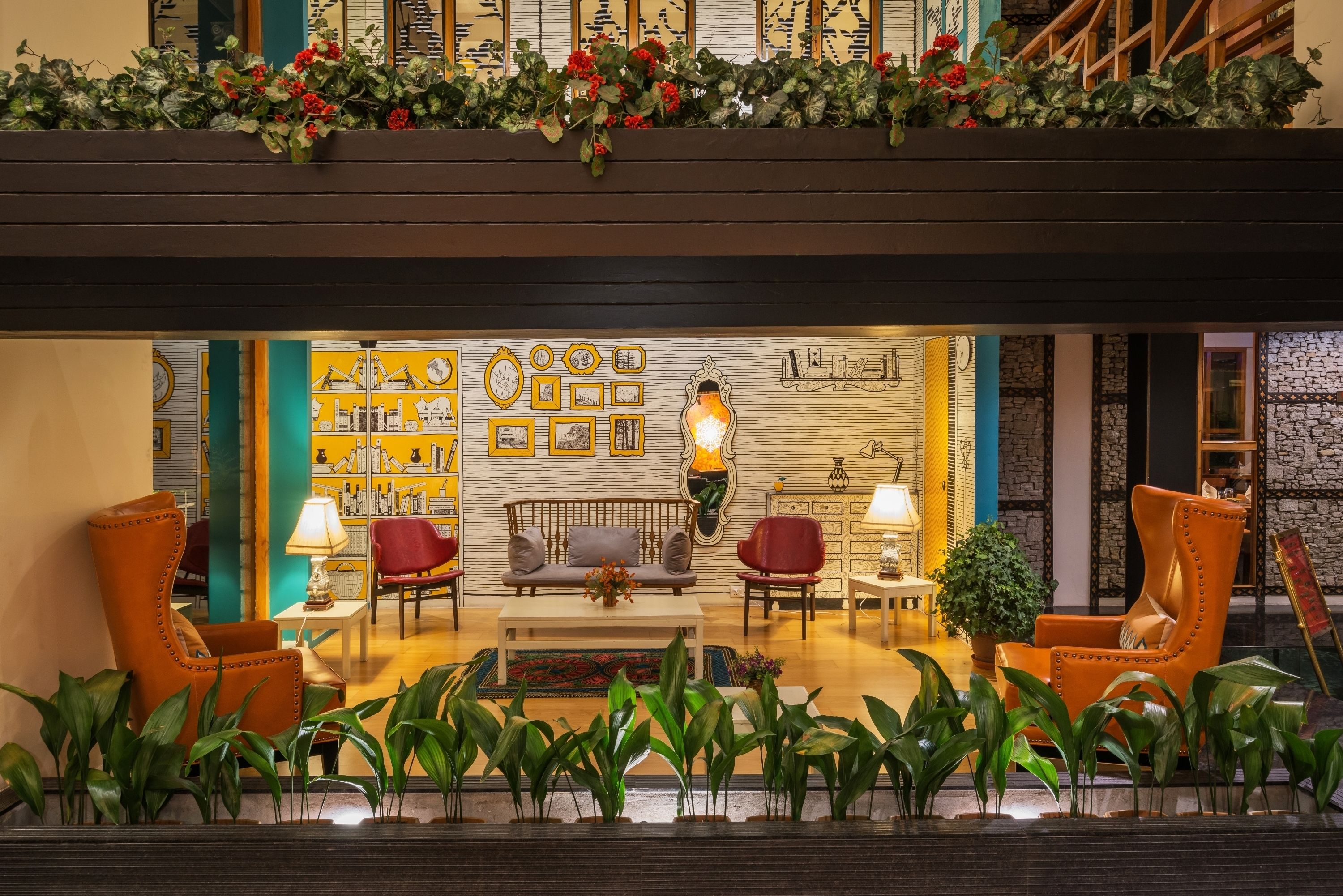 A lobby with a sofa, chairs, a coffee table, and a wall with framed pictures.