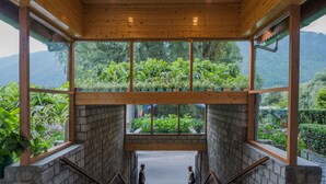A staircase with a view of lush greenery and mountains. - Honeymoon Inn (Manali)