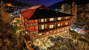 A multi-story building with a red roof, multiple windows, and balconies. - Honeymoon Inn (Manali)