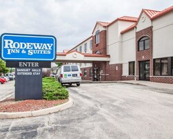 La entrada a un Rodeway Inn & Suites, con un letrero que indica Salas de Banquetos y Estancia Extendida.