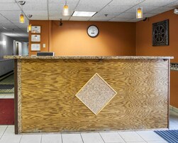 Un mostrador de recepción con acabado de madera y un diseño decorativo de rombos.