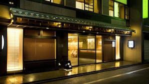 Un edificio japonés tradicional con múltiples ventanas y un toldo verde.