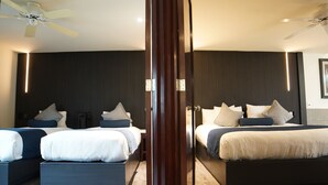 A modern hotel room with a large bed, a smaller bed, and a seating area. - FlowSuites Polanco (Mexico City)