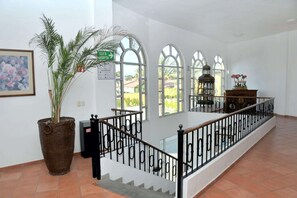 A spacious interior with a staircase, large windows, and a potted plant. - Best Western Saltillo (Saltillo)
