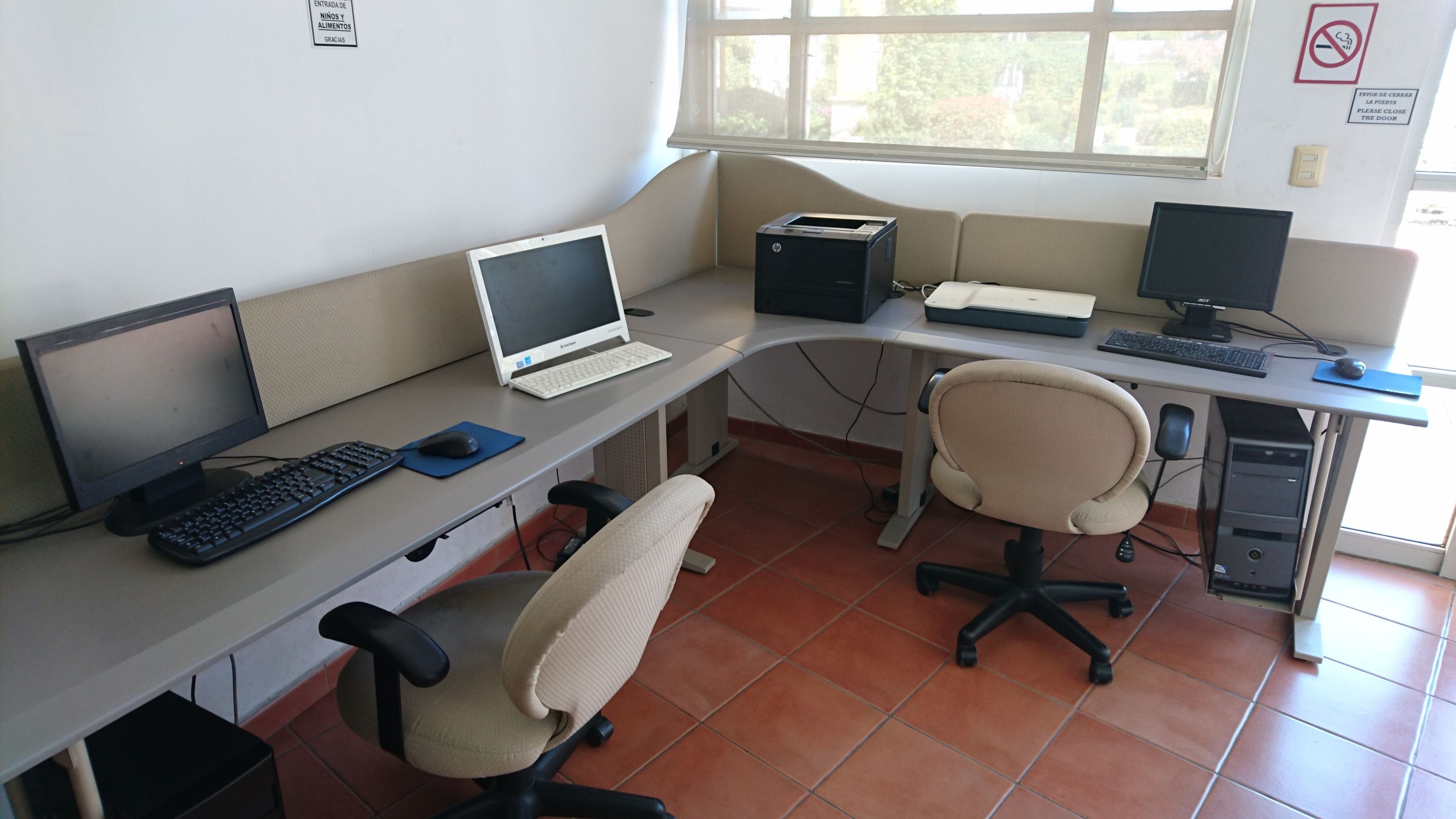 Un laboratoire informatique doté de plusieurs postes de travail, chacun étant équipé d’un ordinateur de bureau, d’un clavier et d’une souris.