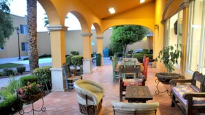 An outdoor patio area with seating arrangements, a palm tree, and a well-maintained garden. - Best Western Saltillo (Saltillo)