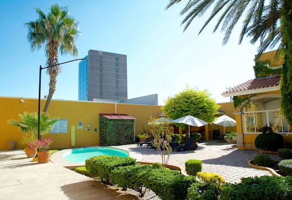 A courtyard with a swimming pool, palm trees, and outdoor seating. - Best Western Saltillo (Saltillo)
