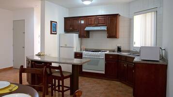 A kitchen with wooden cabinets, a stove, and a refrigerator.
