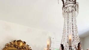 A dining area with a white fireplace, a large ornate mirror, and a chandelier. - Coppersmith Inn B&B (Galveston)