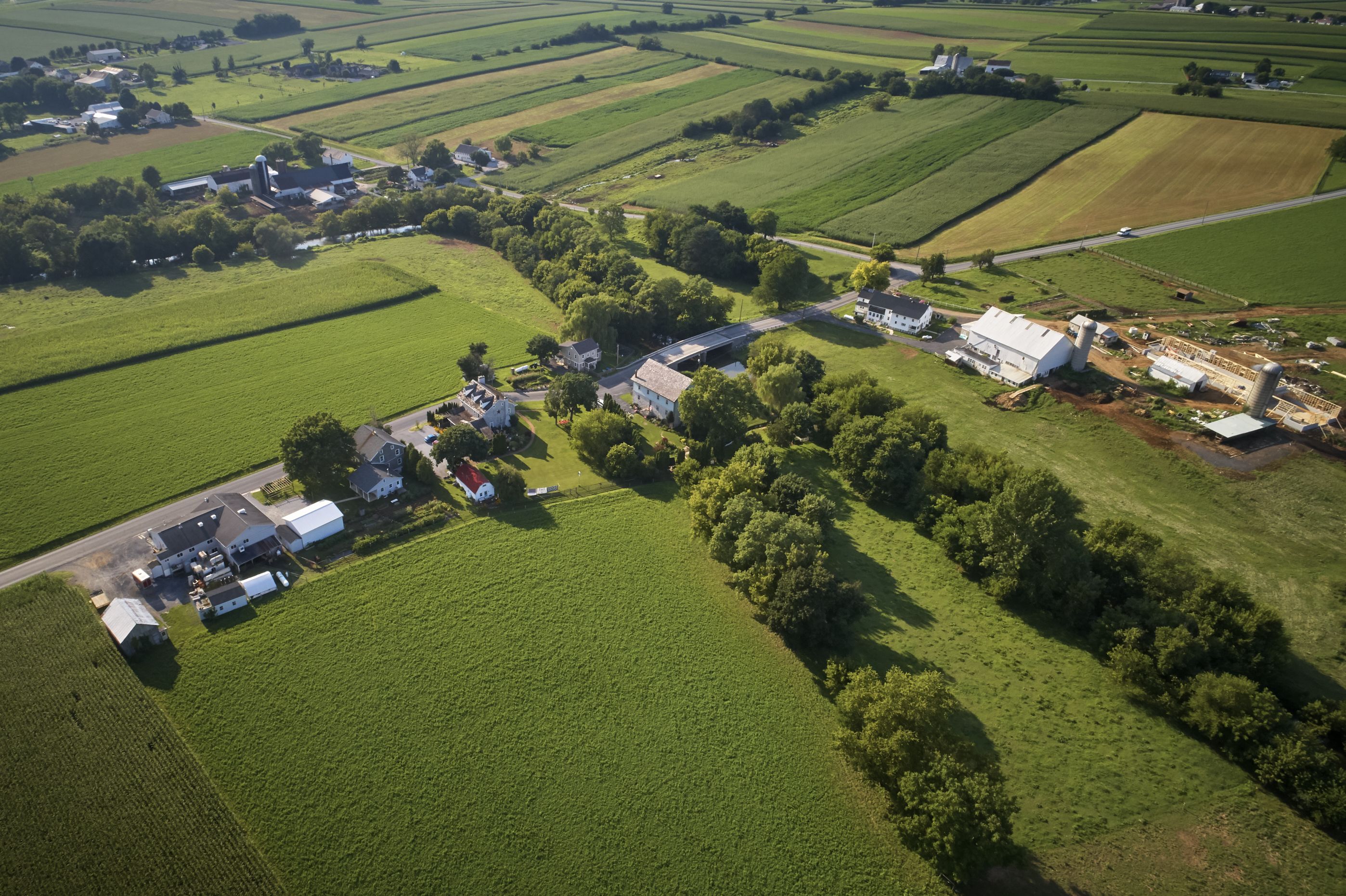 Vista aérea de una zona rural con campos, una casa de campo y un granero.