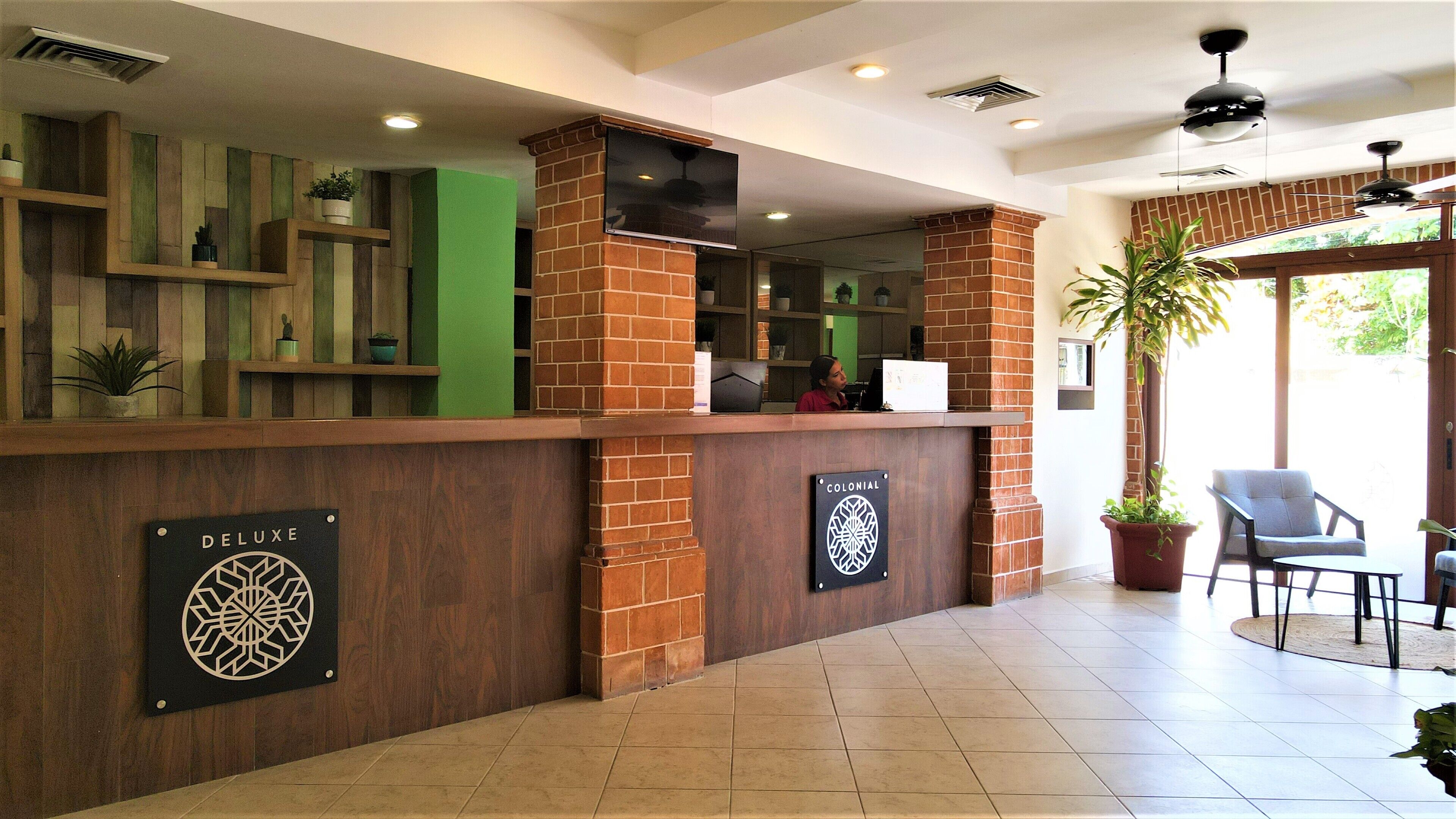 Un'area reception con un bancone in legno, un cartello con scritto 