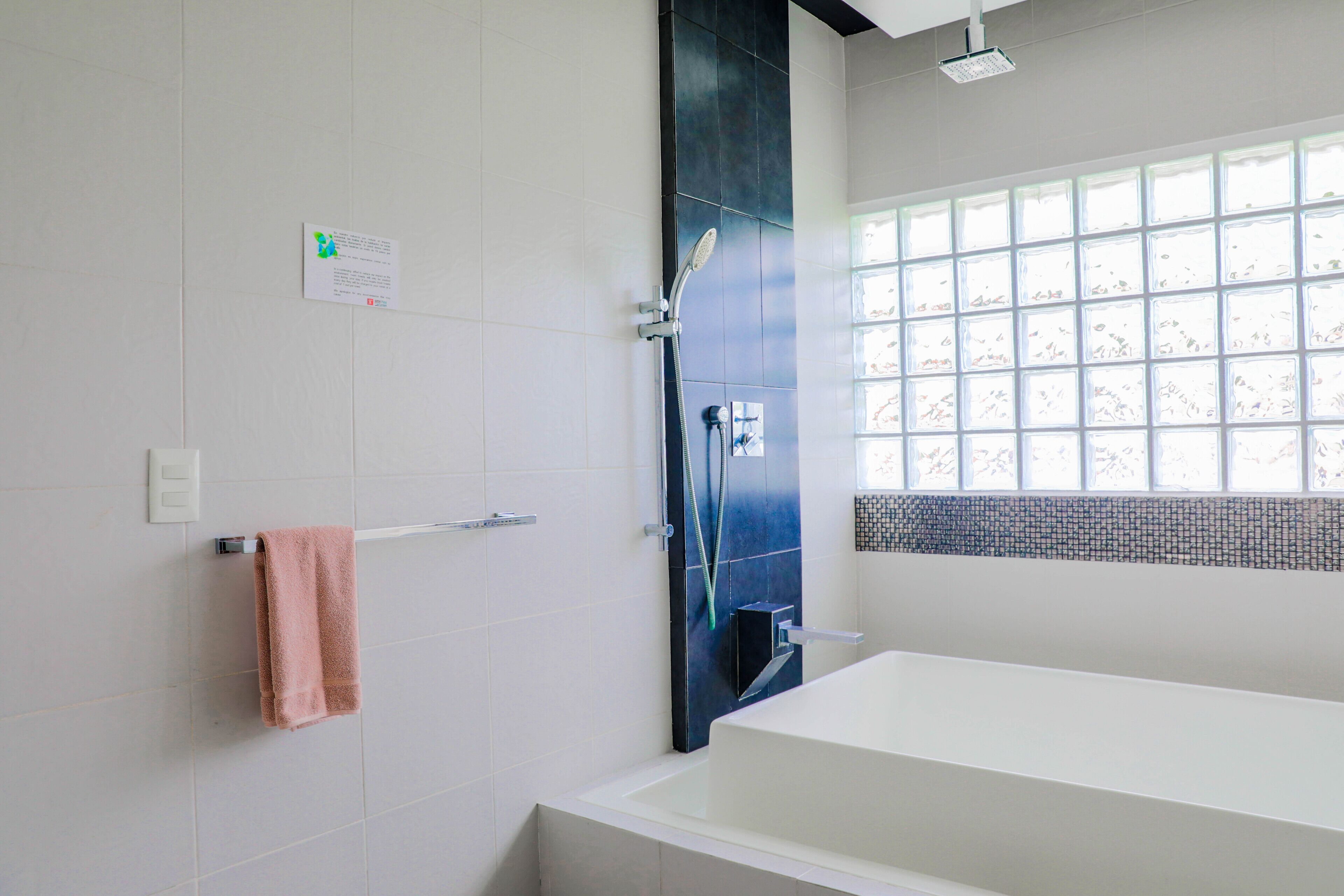 A modern bathroom with a large bathtub, a shower, and a window with a view.