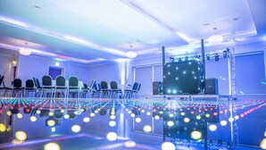 A conference room with a stage, chairs, and a large screen. - Dean Park Hotel (Kirkcaldy)