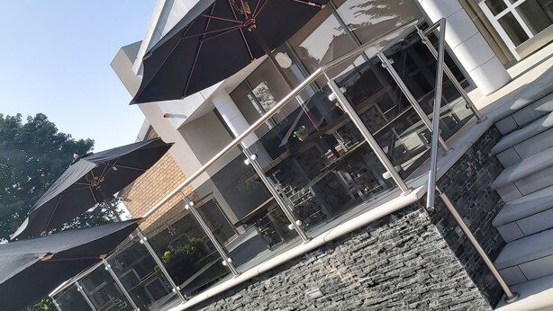 A modern building with a stone facade, outdoor seating area, and a glass entrance. - Dean Park Hotel (Kirkcaldy)