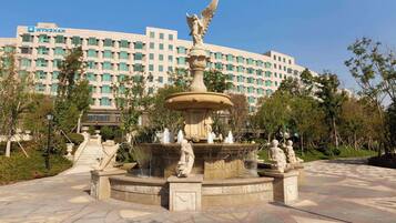 A fountain with statues in front of a Wyndham hotel.