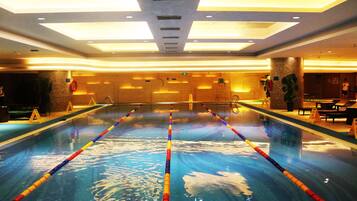 Una piscina techada, sillones reclinables de piscina