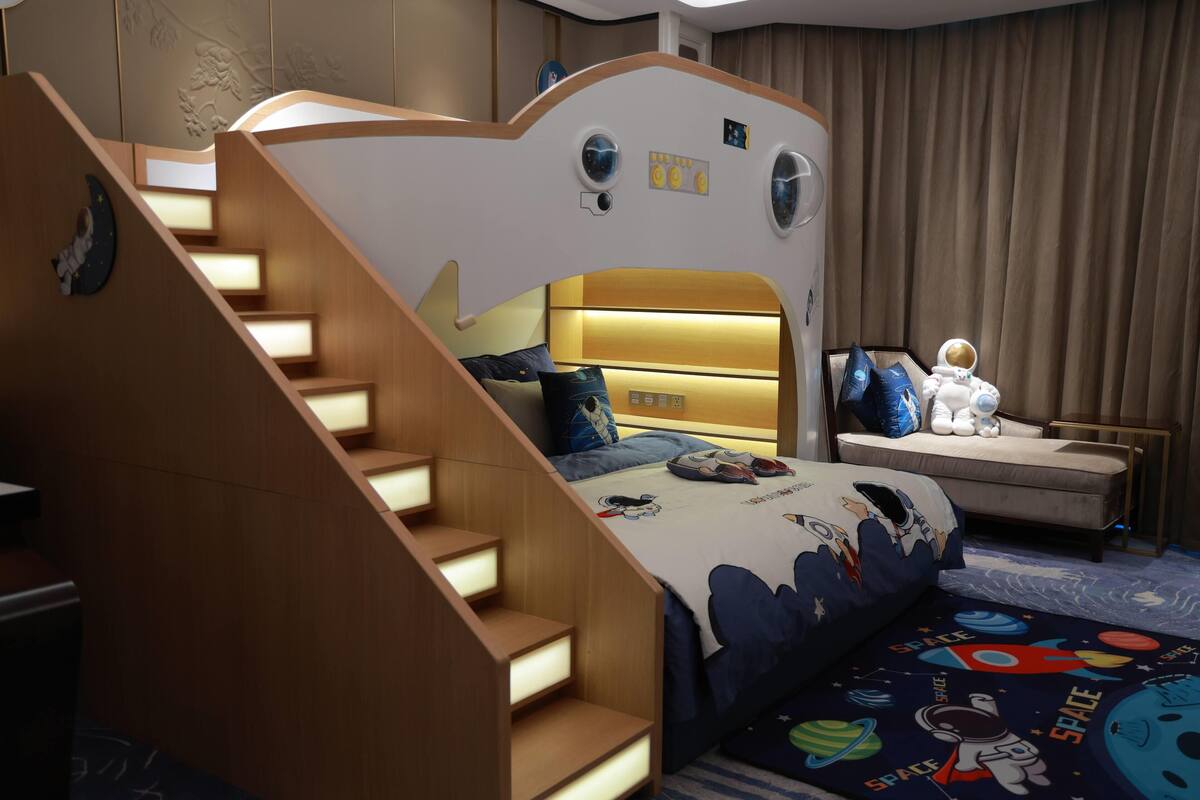 Una habitación infantil con una cama nido, un escritorio y una silla.